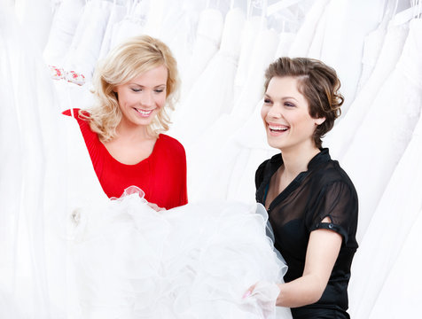 Designer and the client have a good look at the wedding dress