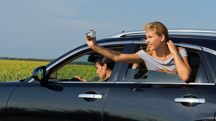 Woman passenger leaning out of car taking photo