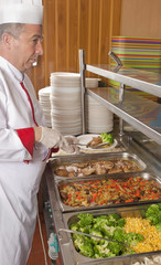 chef standing behind full lunch service station 