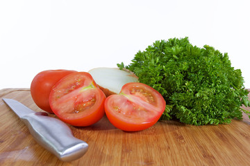 tomates, persil oignons et couteau sur planche a découper