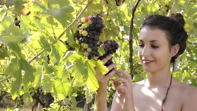 a girl with a bunch of grapes