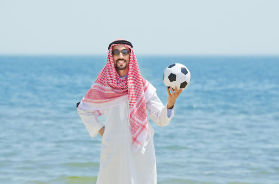 Arab with footbal at seaside