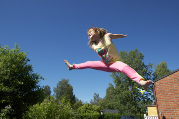 Happy jumping girl on a blue sky background