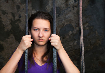 Young woman behind the bars