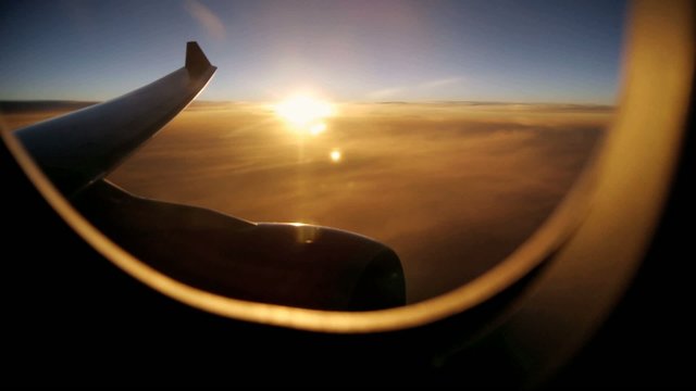 Airplane window view at sunset