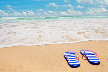 Fototapeta na wymiar Colorful striped sandals on sea beach