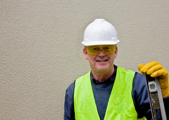 Construction worker leans on spirit level