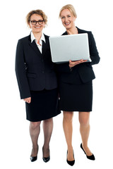 Senior businesswomen posing with laptop