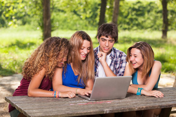 Group of Teenage Students at Park with Computer and Books