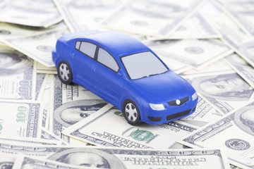 toy car on money as the concept of purchase and sale of cars