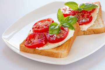 Bread with mozzarella tomatoes and basil leaves