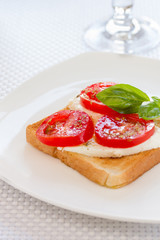 Tasty toast bread with mozzarella tomatoes and basil leaves