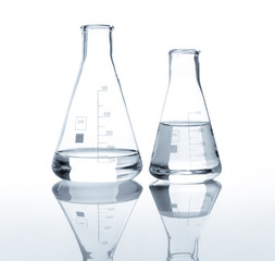 Two laboratory flasks with a clear liquid, isolated