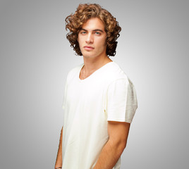 Portrait Of A Serious Young Man Standing On Grey Background