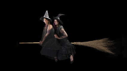 two halloween witches flying on a broom