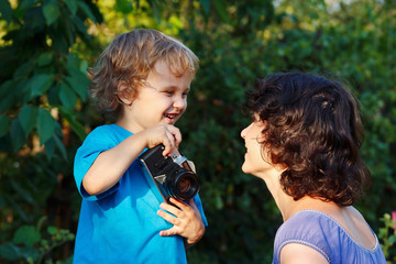 Obraz premium Young smiling photographer with a camera shoots her mother