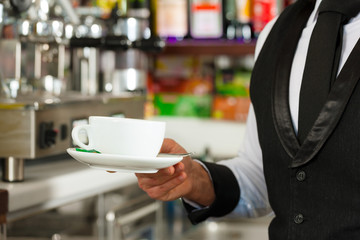 Barista bereitet Cappuccino zu in seinem Cafe