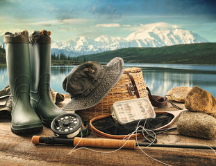 Fly fishing equipment on deck with view of a lake and mountains - 43789818