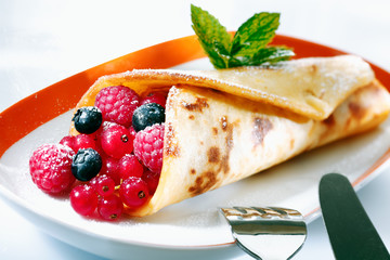 Golden pancake filled with berries