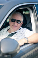 Handsome middle-aged man driving a modern car