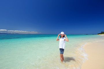 Fototapeta na wymiar 水納島のビーチで遊ぶ笑顔の女性