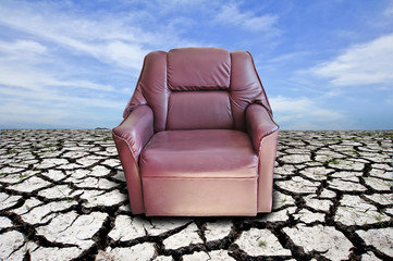red armchair on cracked dried soil