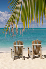 Two Beach chairs on white sand and  blue sky
