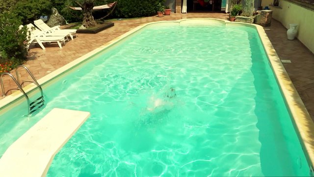 boy diving and swimming into pool