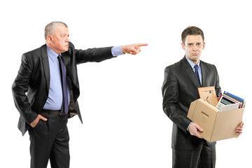 Angry boss firing a man carrying a box of personal items