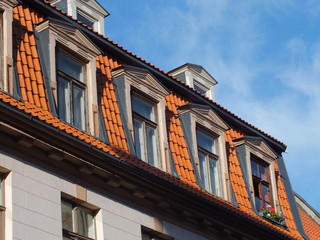 Obraz premium Red roof, dormers and flowers (Riga, Latvia)