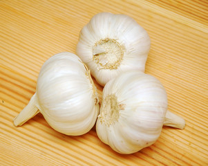 Three garlic cloves on wooden background