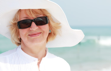 happy senior woman on summer vacation at sea