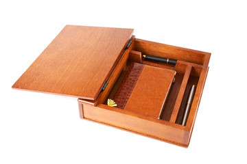 Wooden casket with  notebook and pens on a white