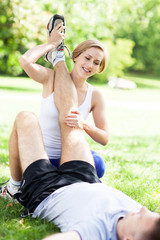 Couple doing stretching exercises in park