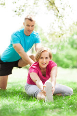 Fototapeta premium Couple doing stretching exercises in park