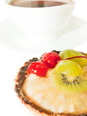Cake with Berries and fruits over white. cup of tee on backgroun