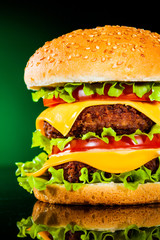 Tasty and appetizing hamburger on a darkly green