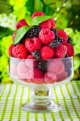Sweet fresh fruits in glass goblet with mint leaf
