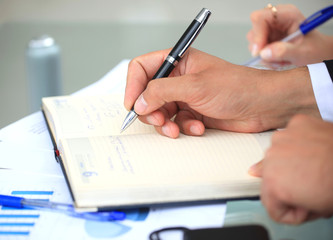 Hands writing on a paper