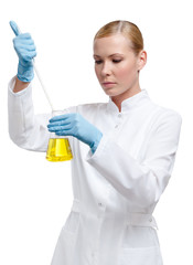 Chemist pours something to the yellow liquid in the flask