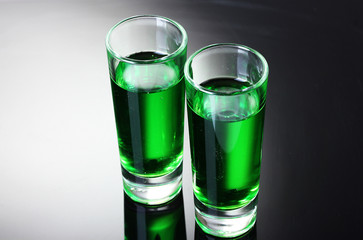 Two glasses of absinthe on grey background