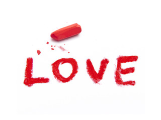 word LOVE and red pastel crayon