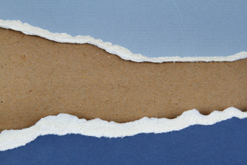 Ripped blue paper on brown background. Copy space