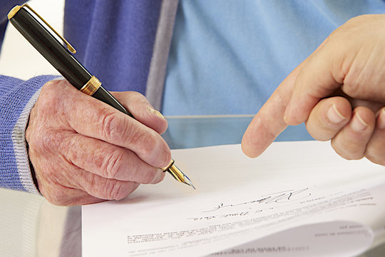 Femme âgée signant un contrat