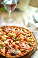 Original Italian seafood pizza sliced on wood dish and water din