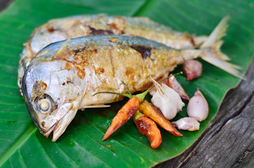 Fish grilled on a banana leaf background