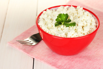 cottage cheese with parsley in red bowl and fork