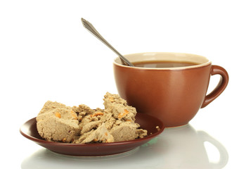 A cup of tea and saucer with delicious halva isolated on white