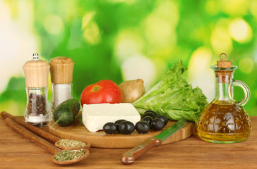 Ingredients for a Greek salad on green background close-up
