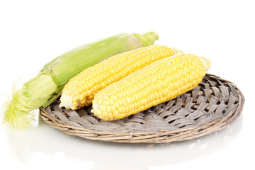 Fresh corn cobs on wicker mat isolated on white
